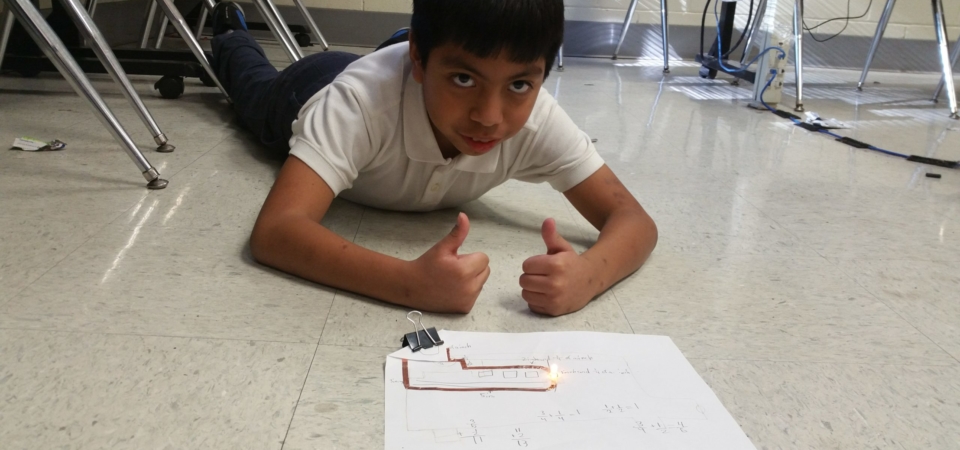4th Grader building simple circuit LED light