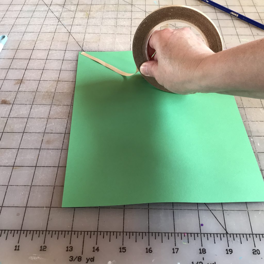 add double sided tape to the paper at angle