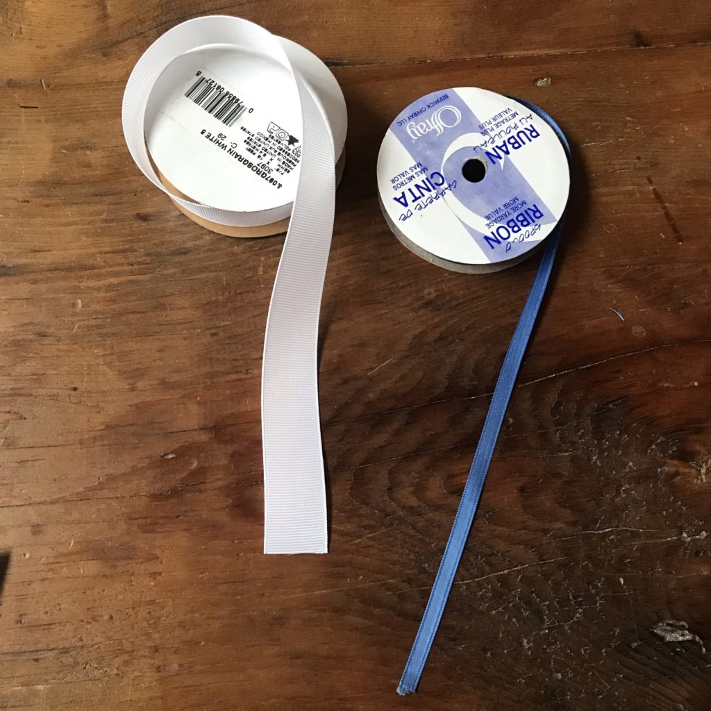 Two rolls of nylon based ribbon sit on a wooden table
