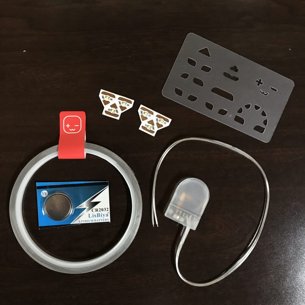 Conductive fabric tape, a coin cell battery, LED stickers