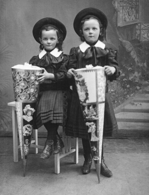 Two little girls holding school cones