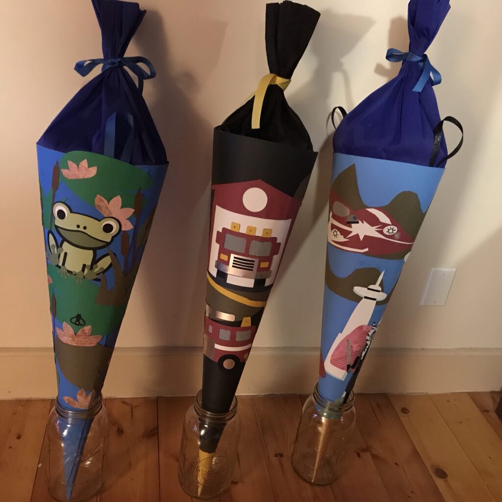 Three Schultüte (school cones) held up by glass jars