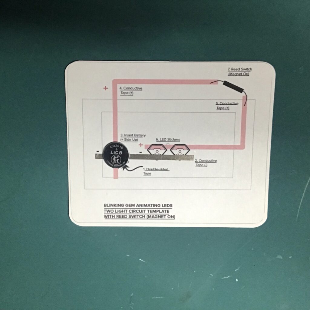 A CR2016 coin cell battery has been placed upon the circular footprint on a circuit diagram.