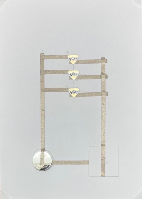 A parallel circuit with a switch in the bottom right corner and a coin cell battery in the bottom left corner has been constructed with conductive fabric tape and 3 Circuit Sticker LEDs.