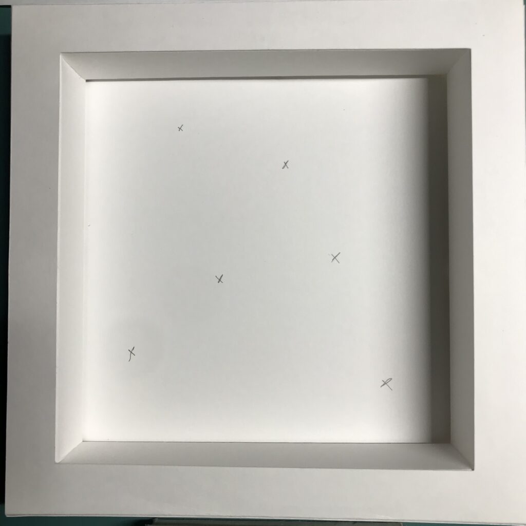 A white, square, box frame with an opening in the center for a layered shadow box insert.