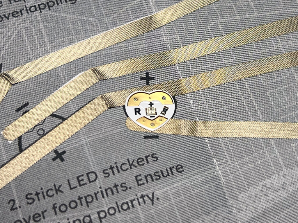 An LED sticker aligned with the positive and negative traces