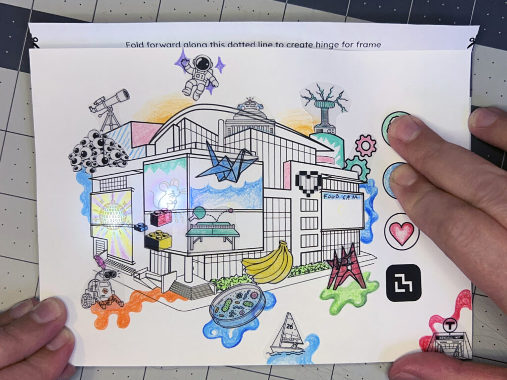 A colorful Media Lab collage with an astronaut, paper crane, robots, and hidden light-up images